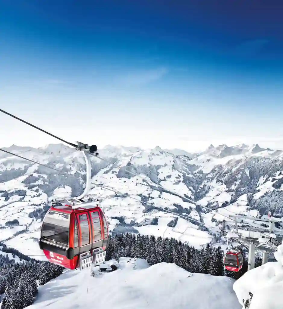 Panoramablick auf breite Skipisten und verschneite Berggipfel in den Kitzbüheler Alpen