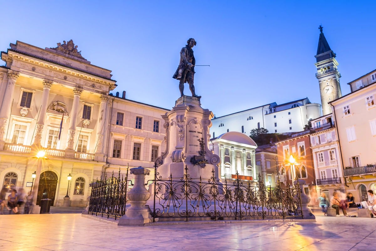 Tartini-Platz in Piran mit Denkmal und Kirchturm in der Abenddämmerung.