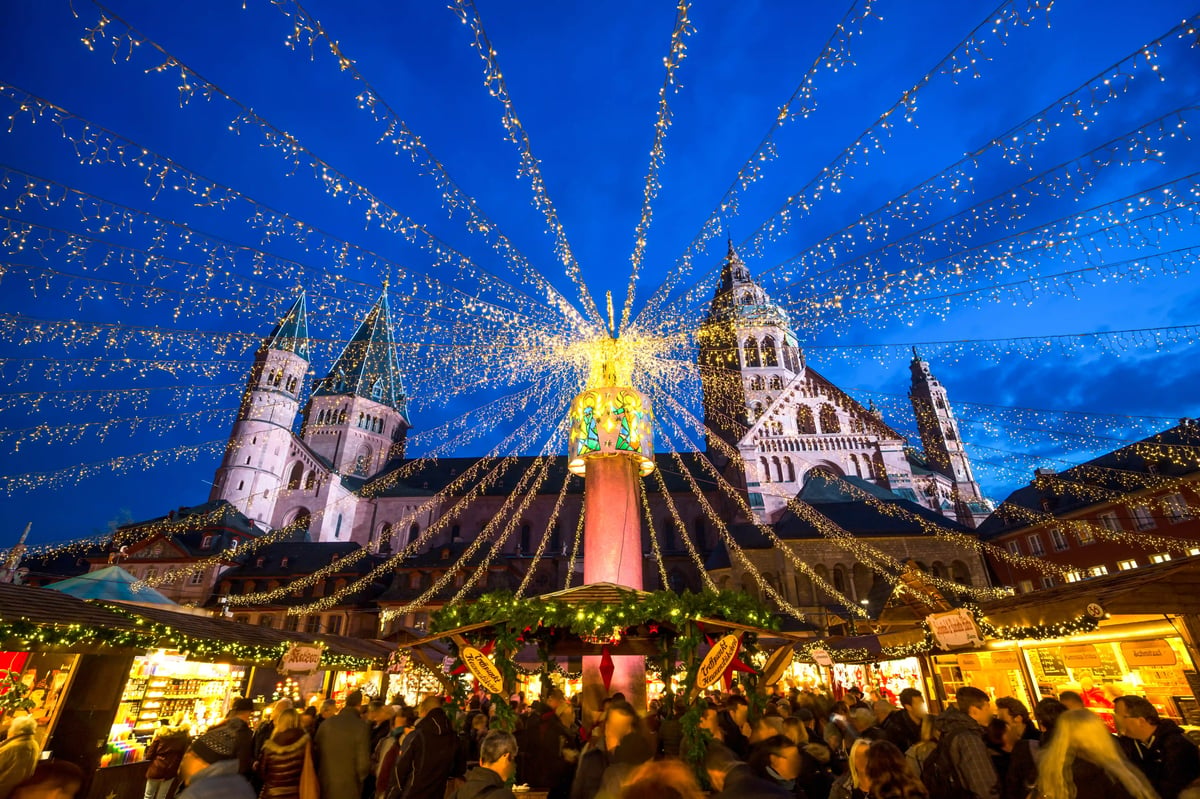 Marché de Noël illuminé devant la cathédrale de Mayence avec de nombreux visiteurs en soirée.