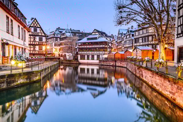 Winterliche Altstadt von Strassburg mit Fachwerkhäusern am Kanal, Lichter spiegeln sich im ruhigen Wasser