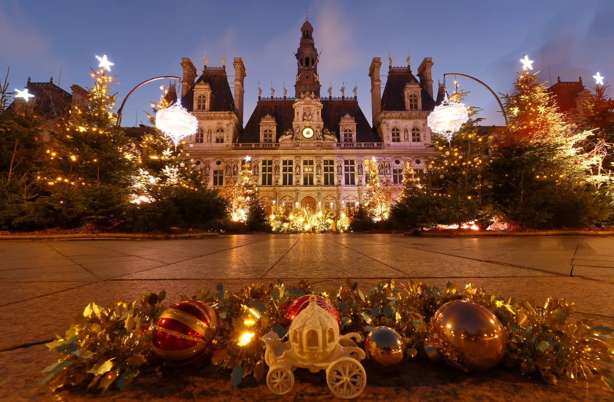 Sapins de Noel illumines devant l'Hotel de Ville de Paris en soiree.