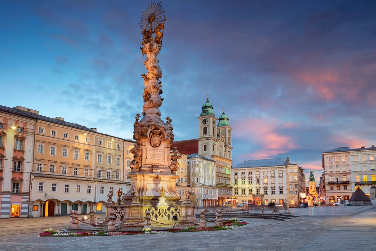 Historischer Hauptplatz in Linz mit Dreifaltigkeitssäule bei stimmungsvoller Abendbeleuchtung