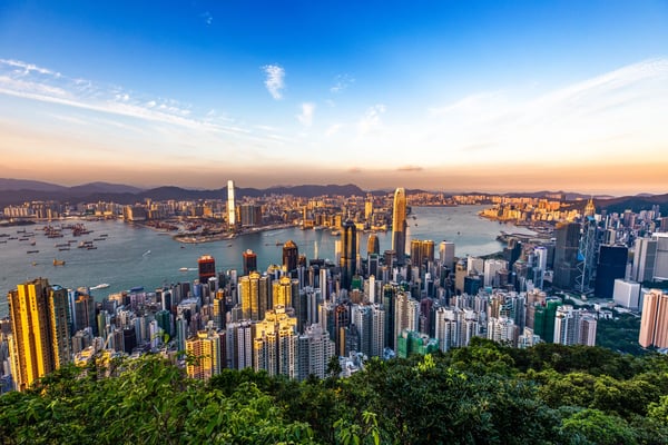 Skyline von Hongkong mit Hochhäusern und Hafen bei Sonnenuntergang