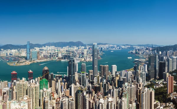 Panoramablick auf die Skyline von Hongkong mit dicht bebauten Hochhäusern und breitem Hafen