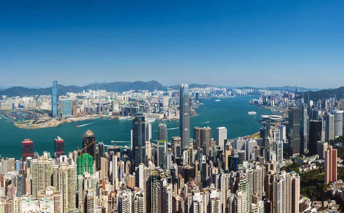 Panoramablick auf die Skyline von Hongkong mit dicht bebauten Hochhäusern und breitem Hafen