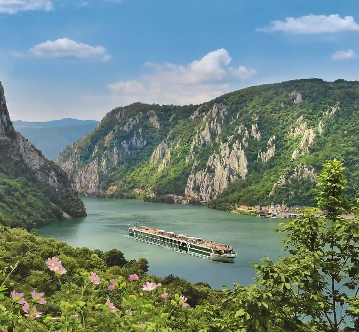 Bateau de croisière fluviale sur le Danube dans un méandre étroit entouré de falaises boisées