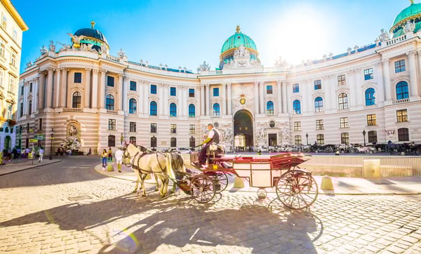 Hofburg in Wien mit barocker Fassade, Kuppeln und Pferdekutsche auf dem Platz