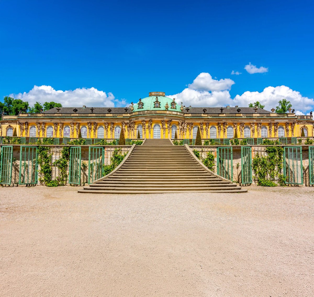 Schloss Sanssouci in Potsdam mit Freitreppe und historischer Fassade unter blauem Himmel