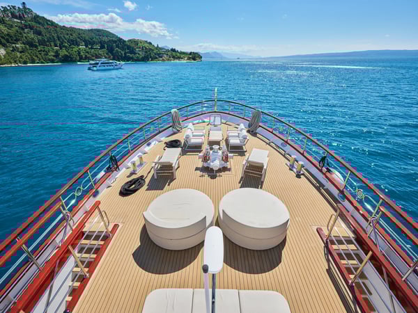 Blick über das Sonnendeck am Bug eines Kreuzfahrtschiffes mit Liegen und offenem Meer