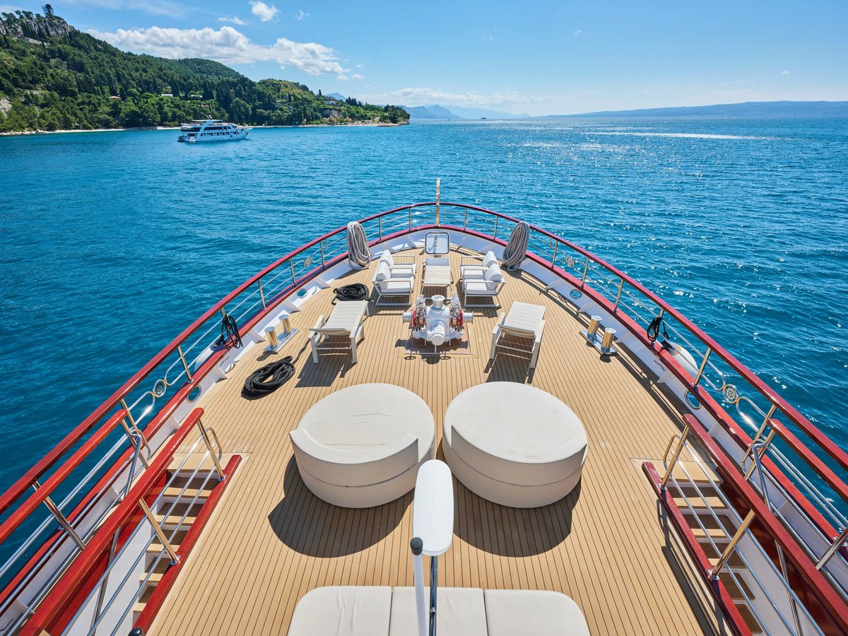 Blick über das Sonnendeck am Bug eines Kreuzfahrtschiffes mit Liegen und offenem Meer