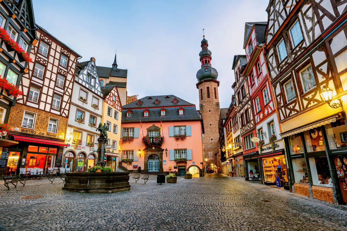 Historischer Marktplatz in Cochem mit Fachwerkhäusern, Brunnen und beleuchteten Gassen am Abend