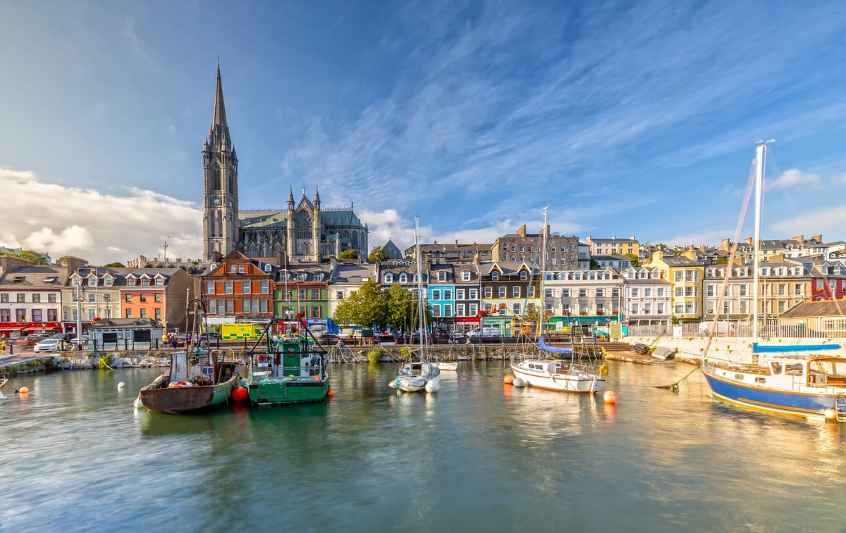 Hafen von Cobh mit bunten Häusern und St. Colman Kathedrale