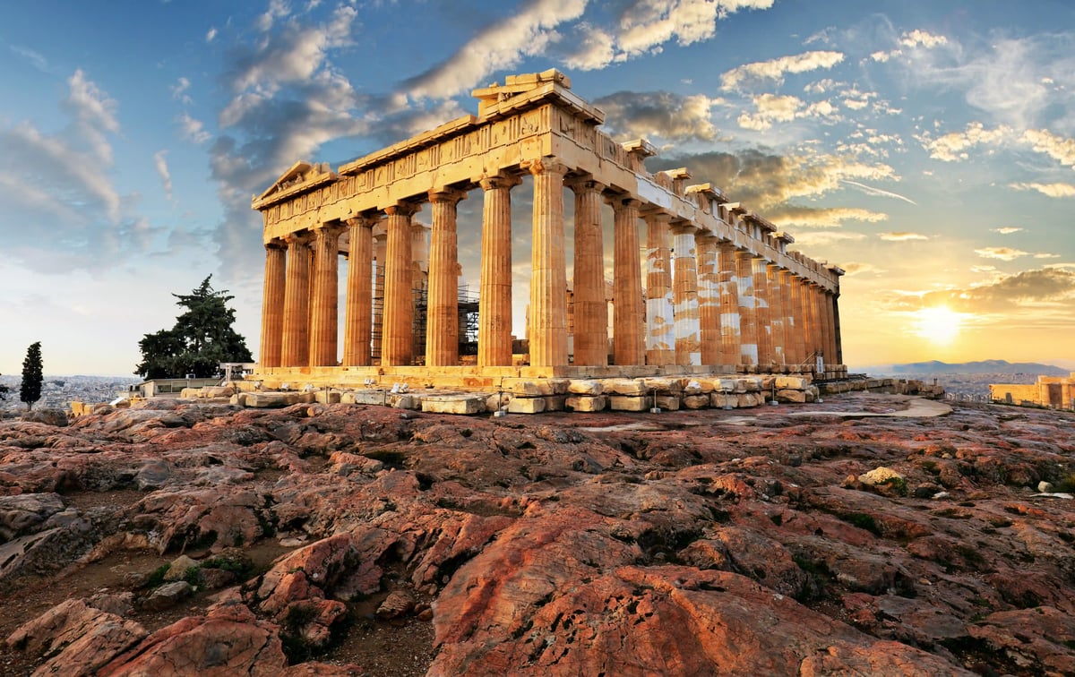 Parthenon Tempel auf der Akropolis in Athen im warmen Abendlicht vor wolkigem Himmel