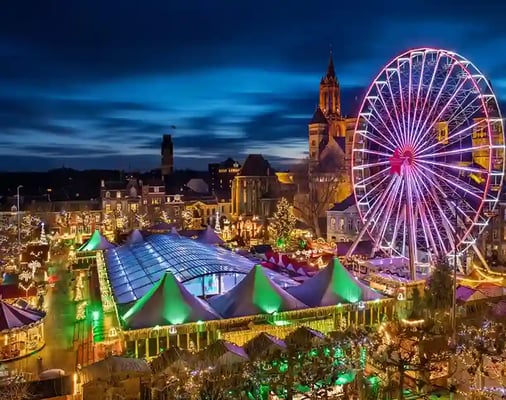 Grosser Weihnachtsmarkt in Maastricht mit Riesenrad, festlicher Beleuchtung und Marktständen bei Nacht