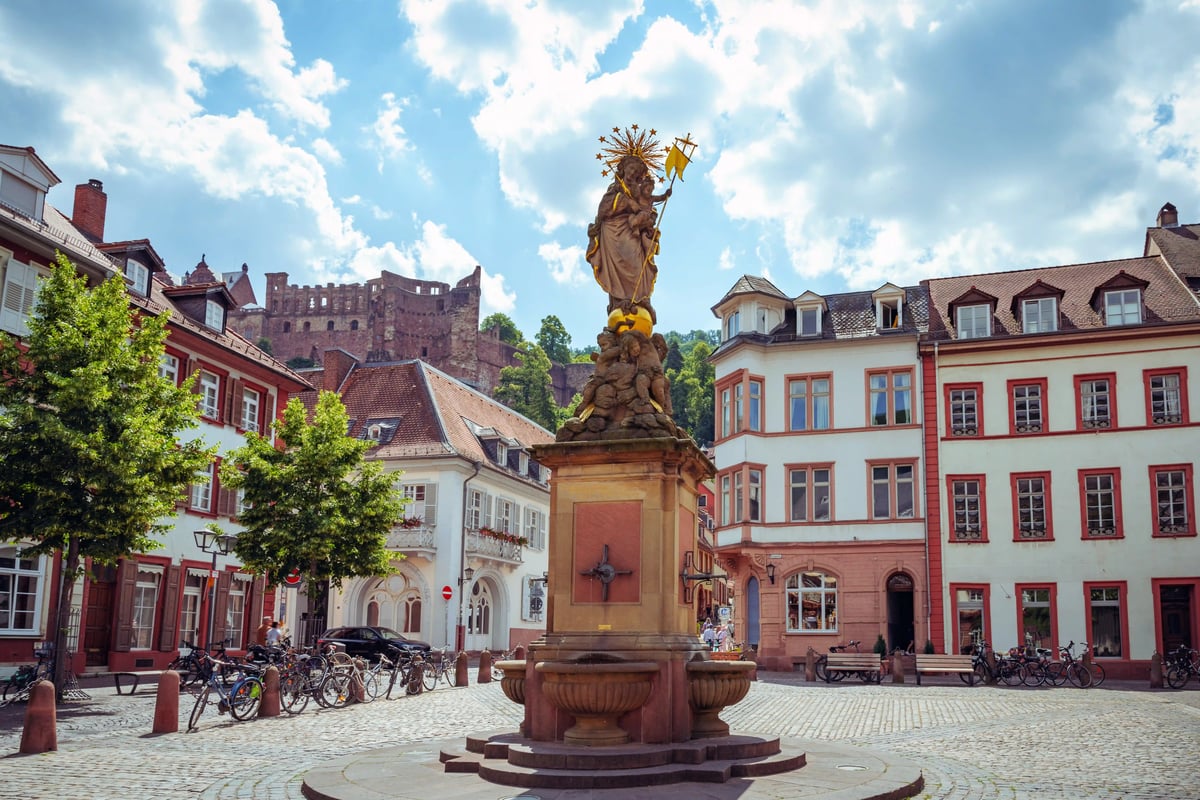 Historischer Kornmarkt in Heidelberg mit Marienstatue und Blick auf die Schlossruine oberhalb der Altstadt