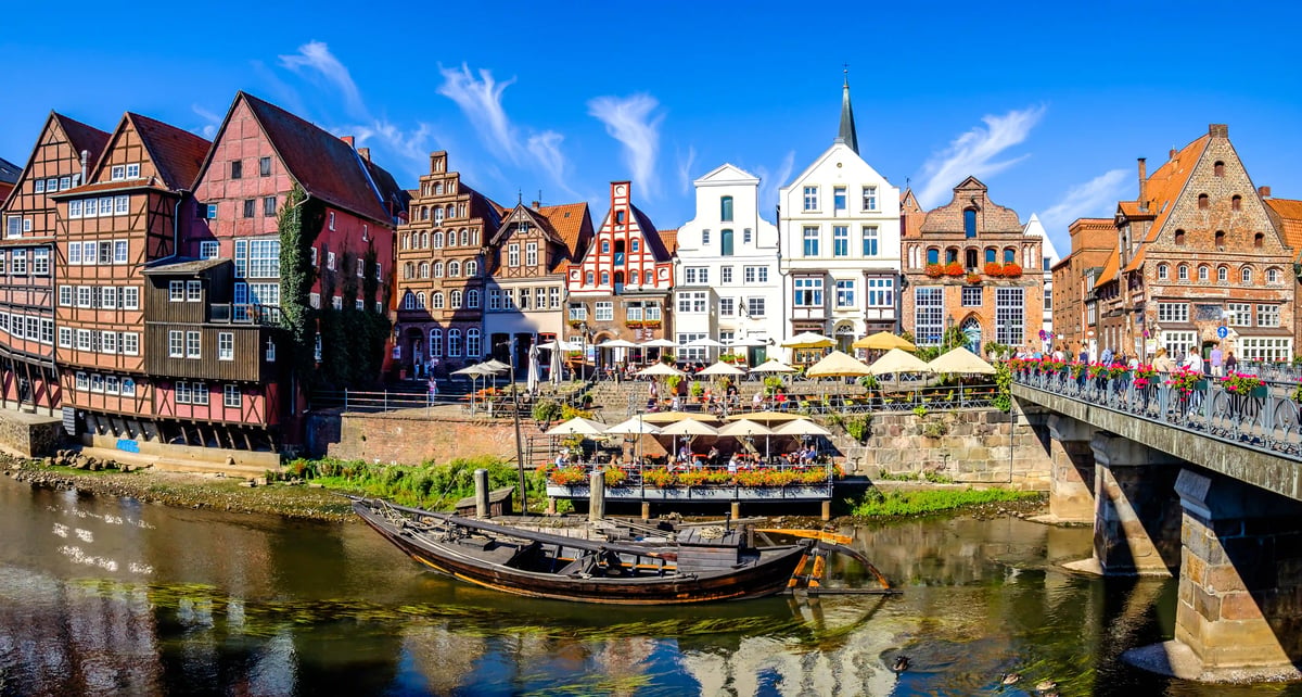 Farbenfrohe Fachwerkhäuser und historische Backsteinfassaden entlang eines Kanals in der Altstadt von Lüneburg
