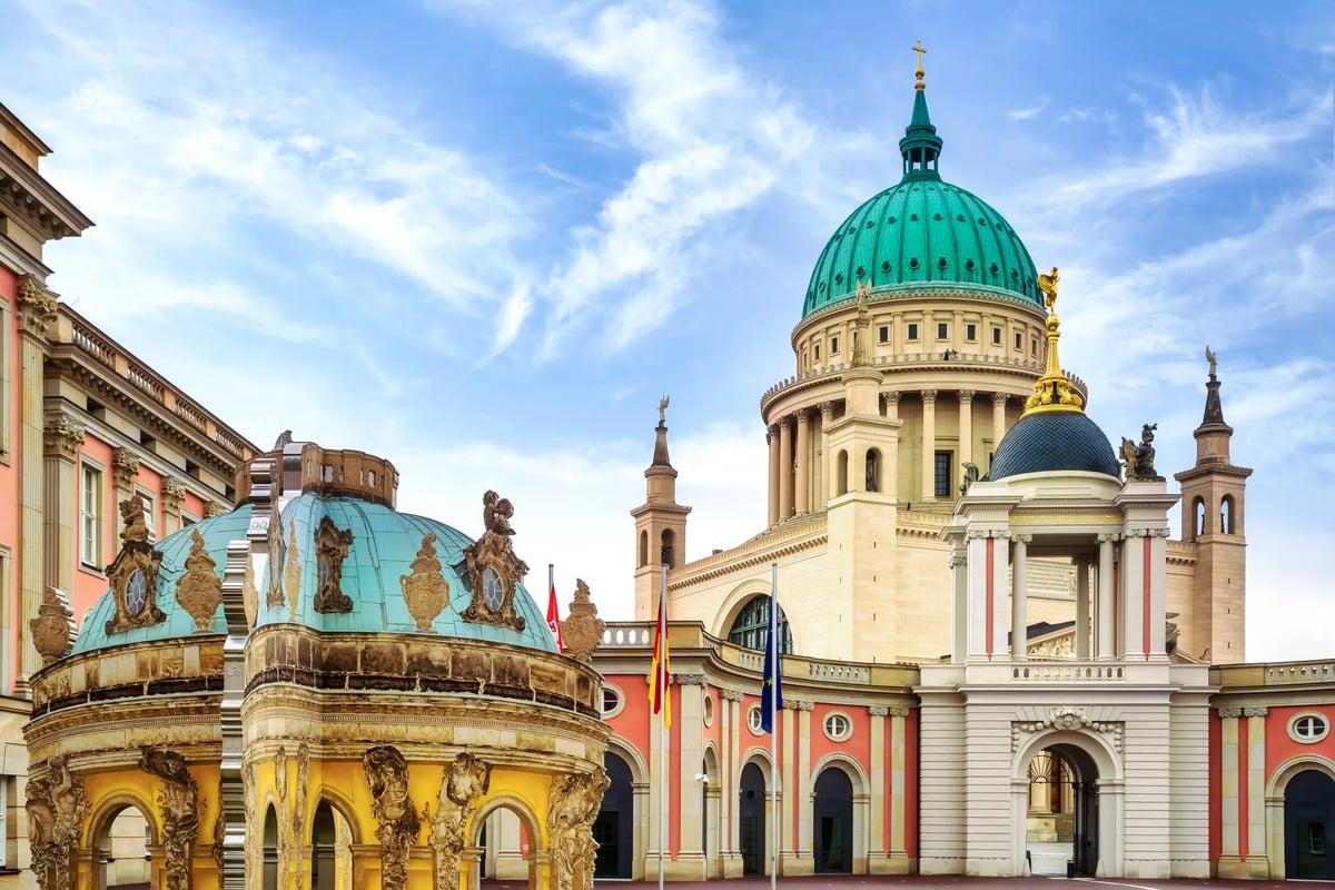 Die Kuppel der Nikolaikirche und historische Gebäude am Alten Markt in Potsdam unter leicht bewölktem Himmel