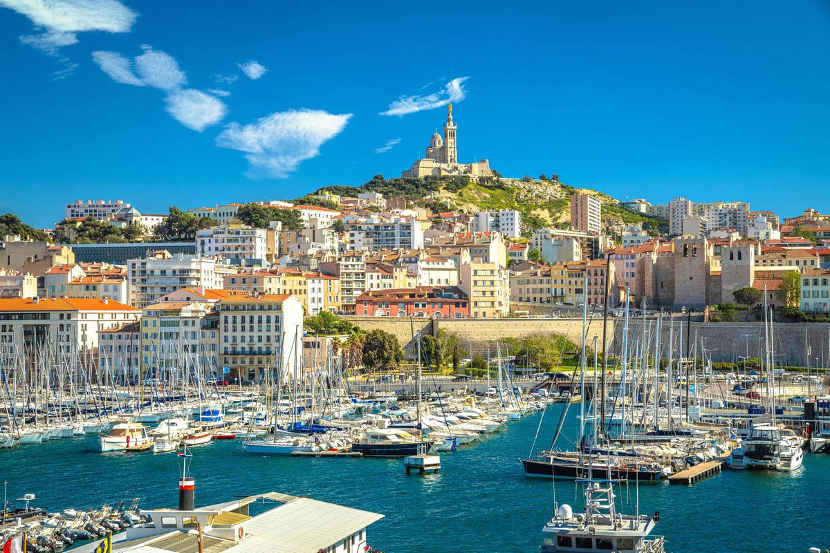 Port de Marseille avec bateaux et vue sur la ville sur une colline avec église