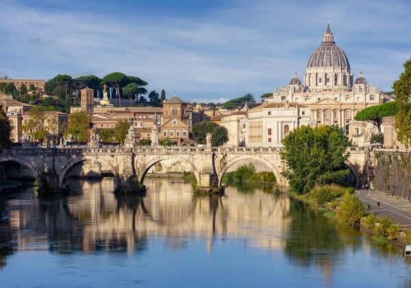 Petersdom in Rom mit Brücke über den Tiber und Spiegelung der historischen Gebäude im Wasser