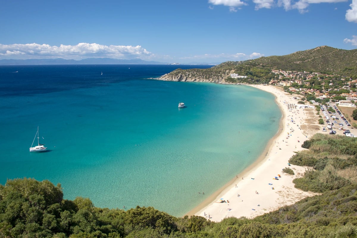 Traumstrand auf Sardinien mit feinem Sand, türkisblauem Wasser und grüner Küstenlandschaft