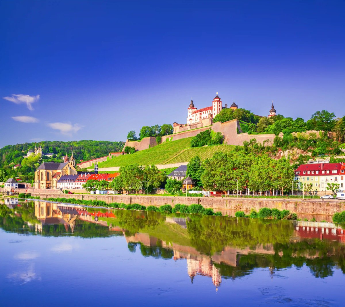 La forteresse de Marienberg domine Wurtzbourg; en bas, les rives et la vieille ville se reflètent dans le fleuve calme.
