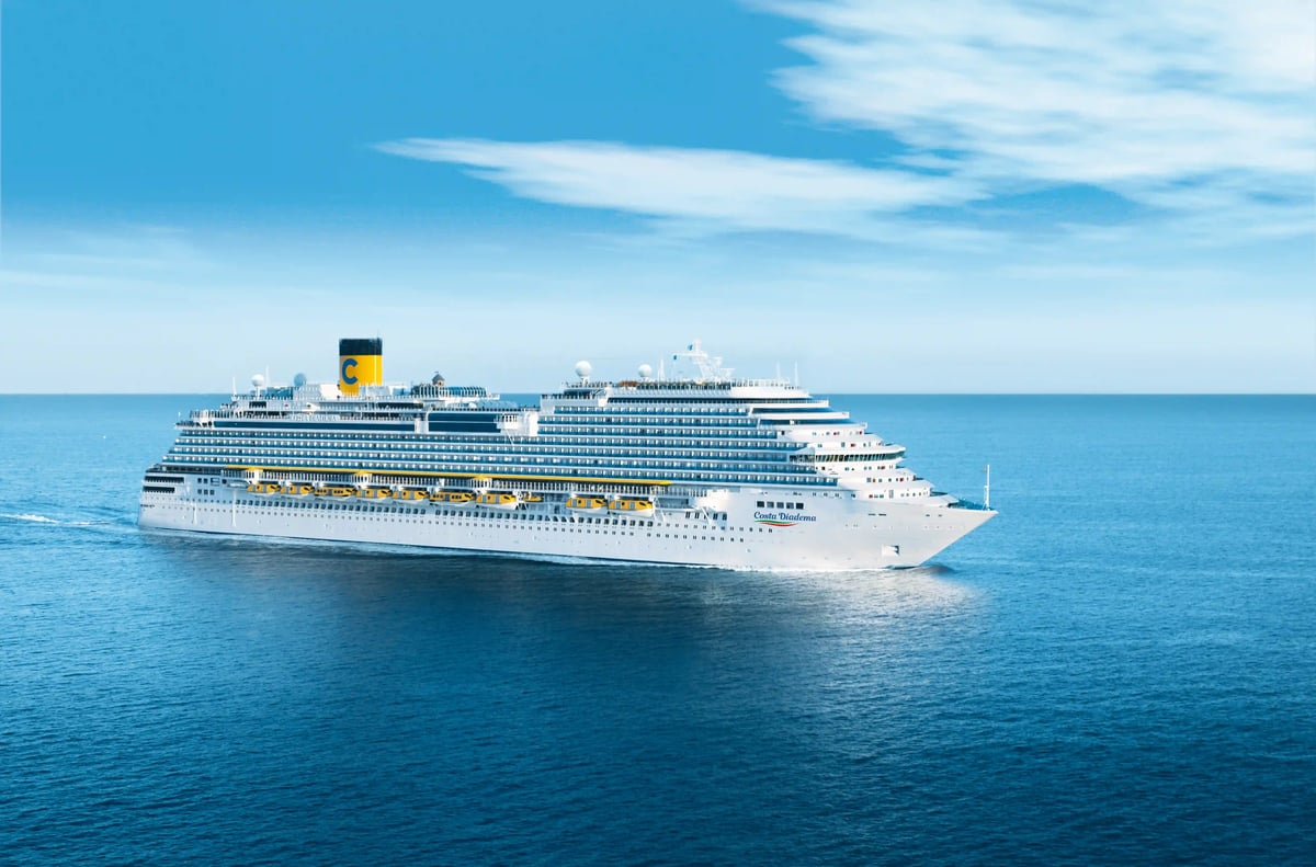 Grosses weisses Kreuzfahrtschiff fährt bei ruhiger See über das offene Meer unter strahlend blauem Himmel