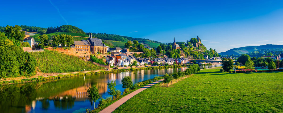Vue panoramique de Saarburg avec la rivière Sarre, des vignobles, des bâtiments historiques et les ruines du château sur une colline