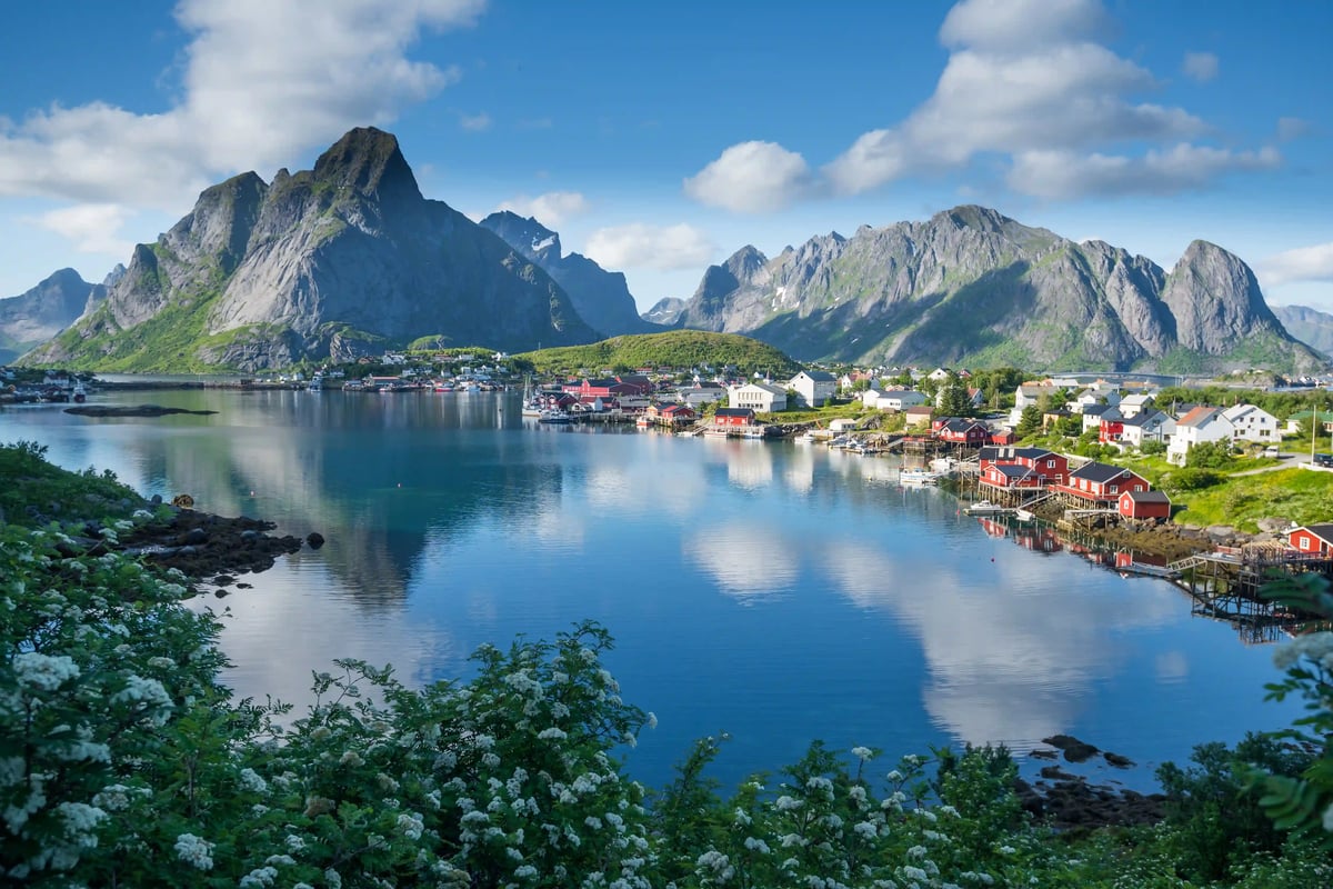 Village pittoresque de Leknes avec maisons rouges, montagnes et fjord paisible