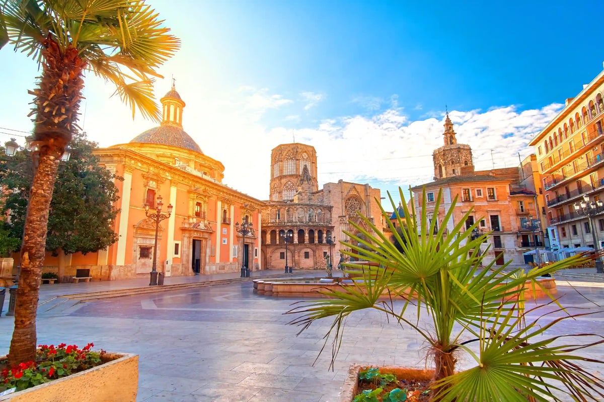 Historischer Platz in Valencia mit Kathedrale, Palmen und farbenfrohen Gebäuden