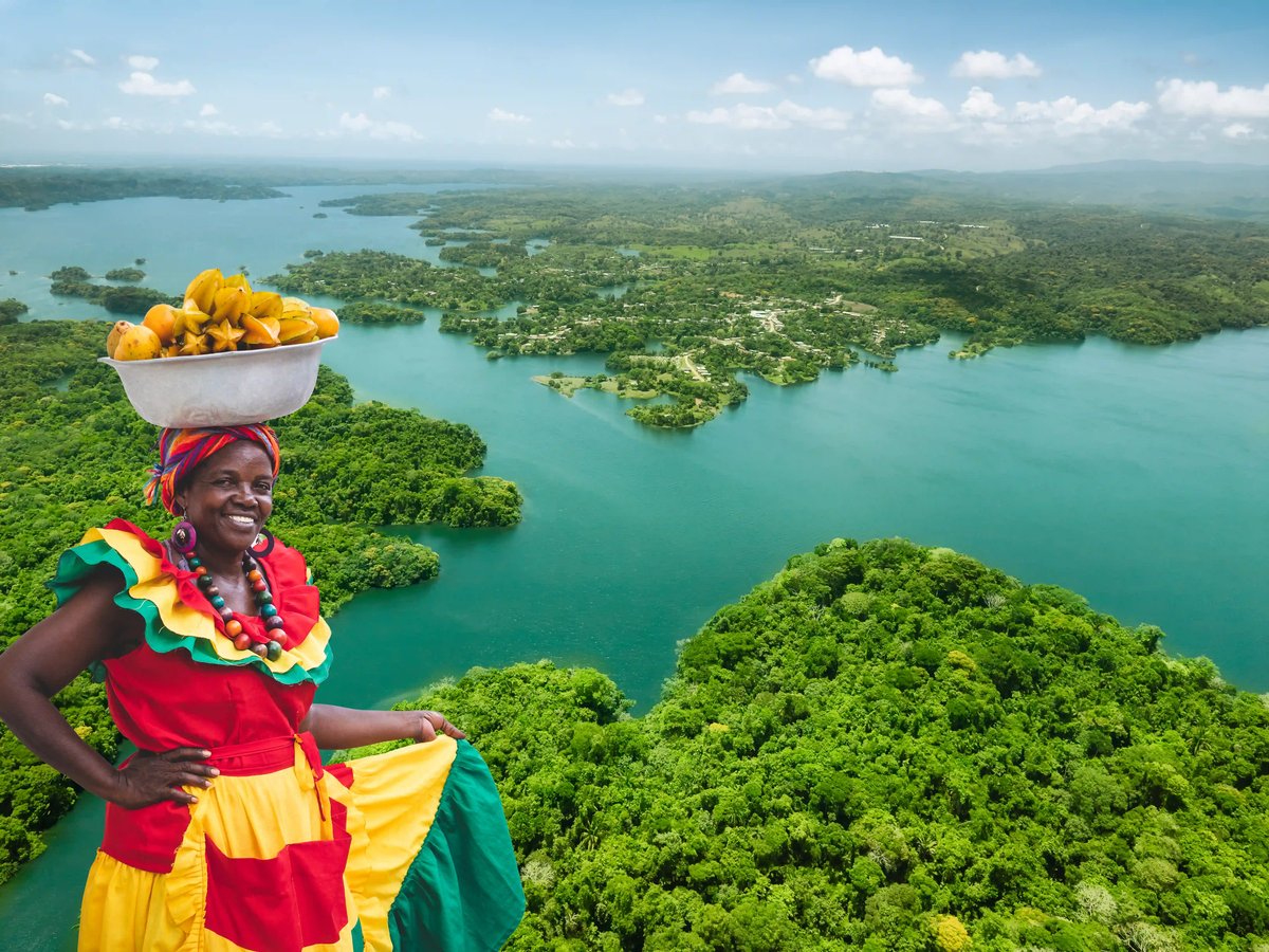 Schiff durchfährt Schleusen des Panamakanals zwischen grüner Landschaft