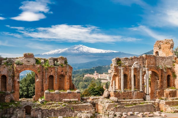 Antike Ruinen in Taormina mit Blick auf den schneebedeckten Vulkan Ätna in der Ferne