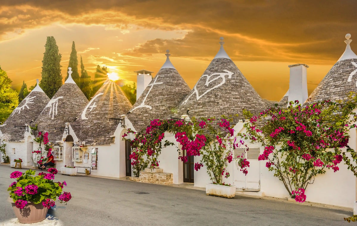 Traditionelle Trullihäuser mit kegelförmigen Steindächern in Alberobello bei warmem Abendlicht