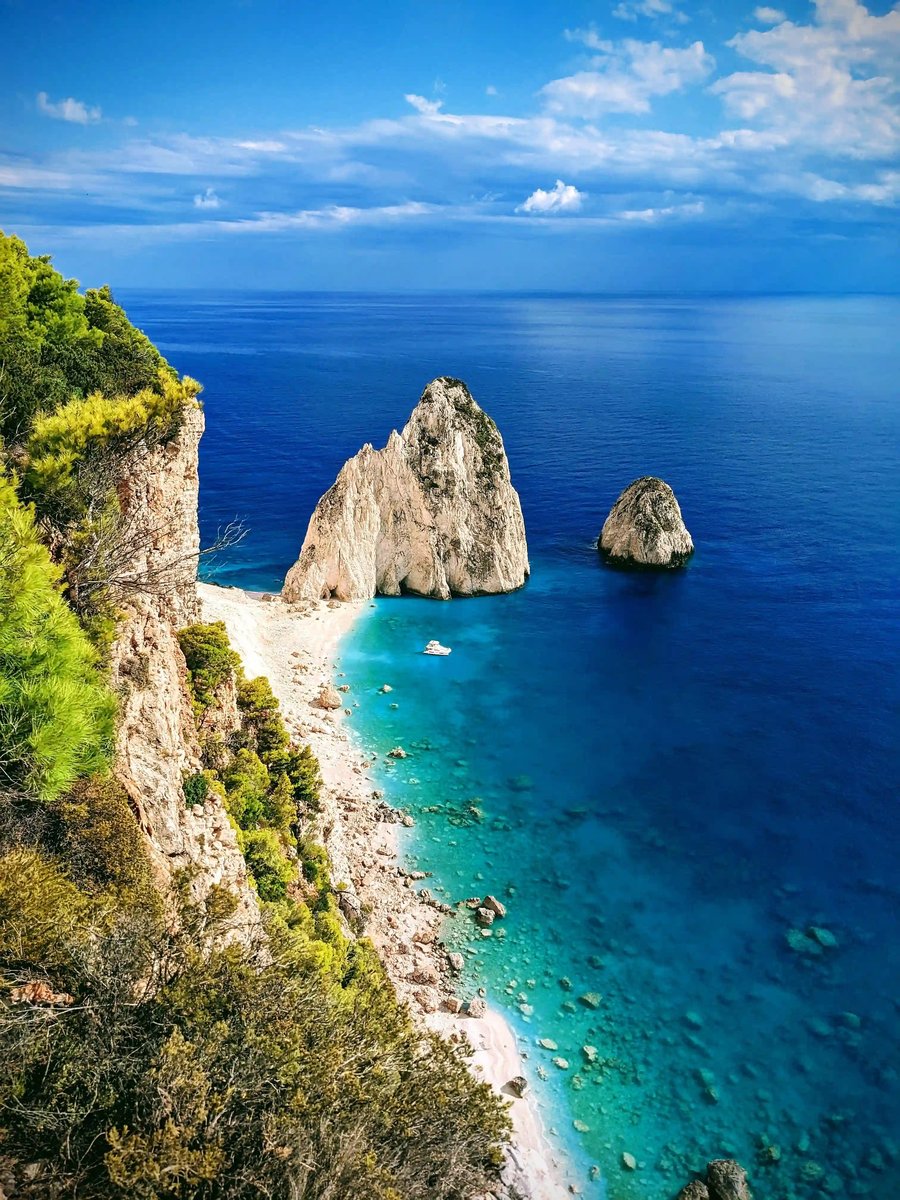 Steilküste auf Korfu mit hellen Felsen, kleinem Strand und klarem blauem Meer