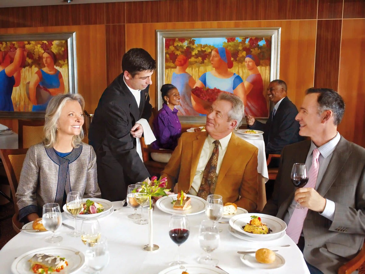 Lassen Sie sich Gäste geniessen ein mehrgängiges Menü in elegantem Restaurant mit Servicepersonal und Weingläsern