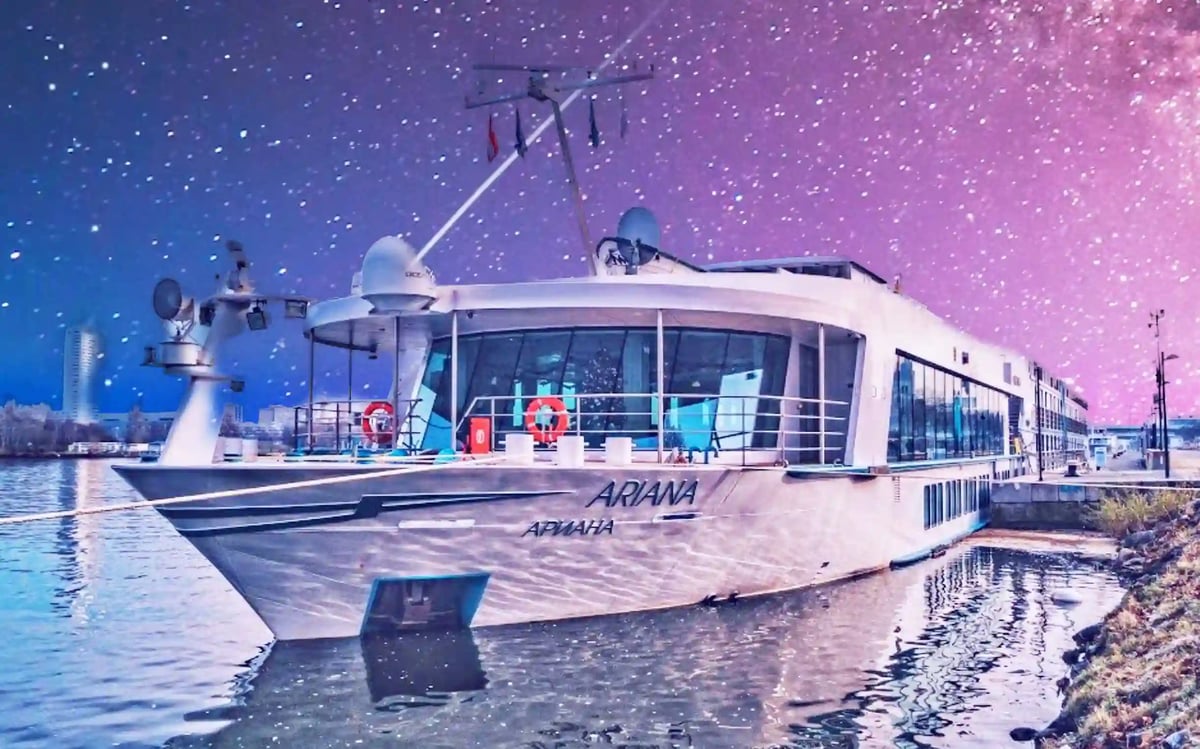 Bateau de croisiere fluviale moderne MS Ariana amarre de nuit au bord de l eau sous un ciel illumine avec reflets sur la surface calme