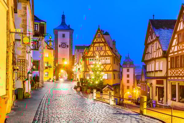 Historische Fachwerkhäuser in der Altstadt von Rothenburg ob der Tauber bei Abendlicht entlang einer gepflasterten Strasse