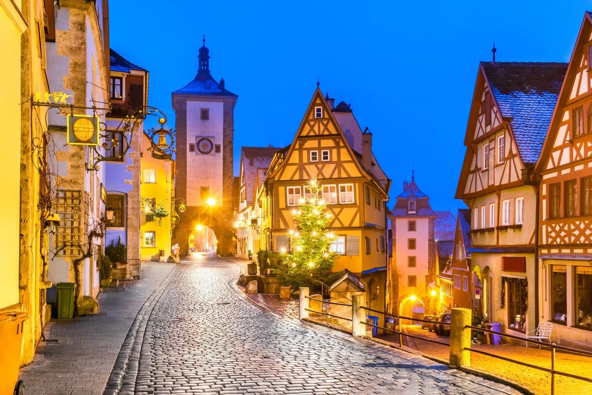 Maisons à colombages historiques dans la vieille ville de Rothenburg ob der Tauber à la tombée du jour le long d'une rue pavée