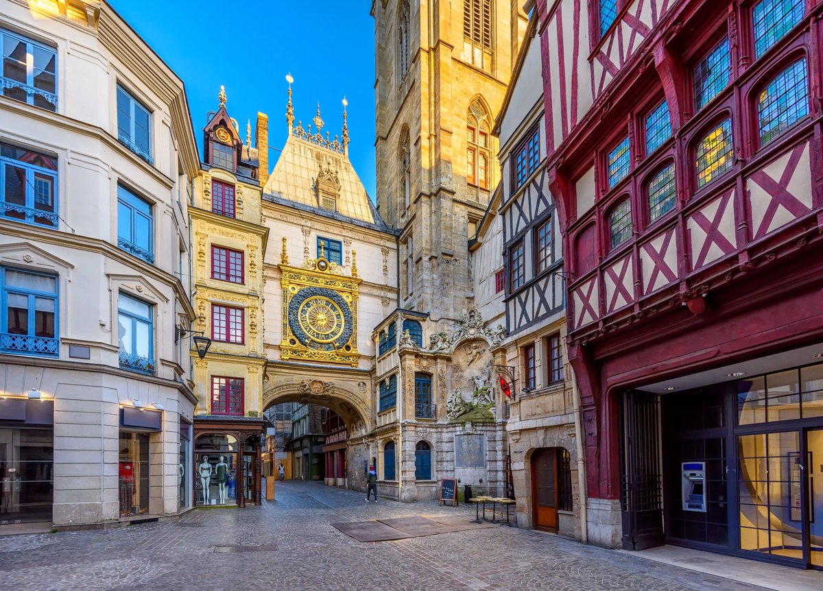 Altstadtgasse in Rouen mit historischen Fachwerkhäusern und astronomischer Uhr am steinernen Torbogen