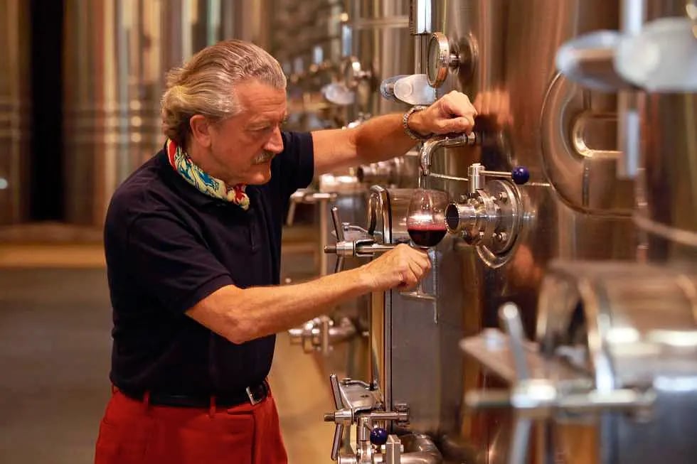 Tagesausflug zu Dieter Meiers WeMann entnimmt Rotwein aus einem Edelstahltank in einer modernen Bodega mit Reihen grosser Weintanksingut Ojo de Agua