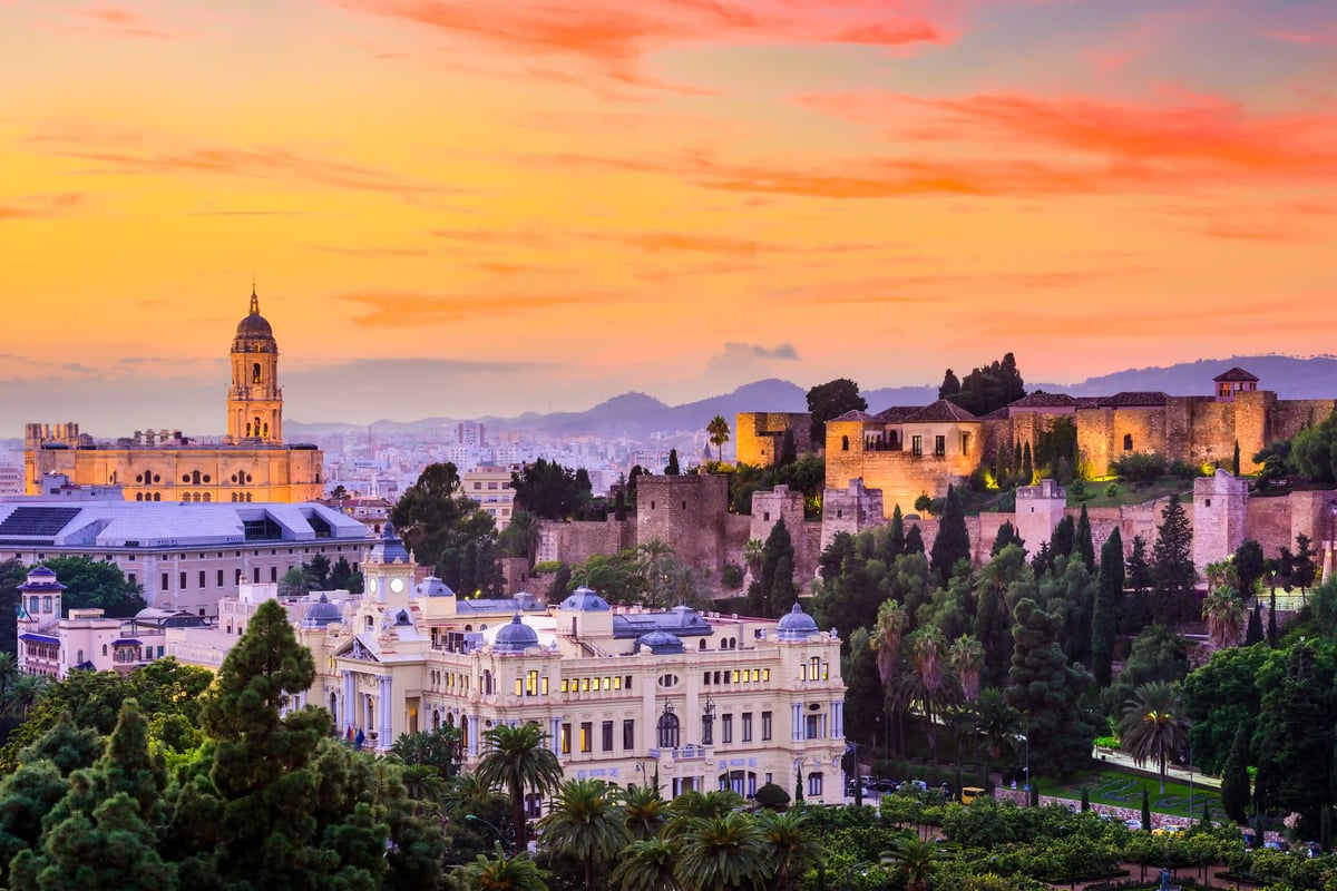 Panoramablick auf Málaga mit historischer Festung, Kathedrale und Stadtlandschaft bei warmem Abendhimmel