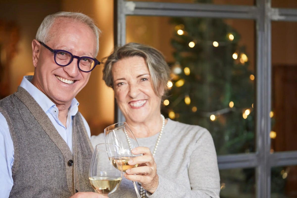 Ein lächelndes Paar geniesst eine Schifffahrt auf der Seine in Paris mit dem Eiffelturm im Hintergrund.