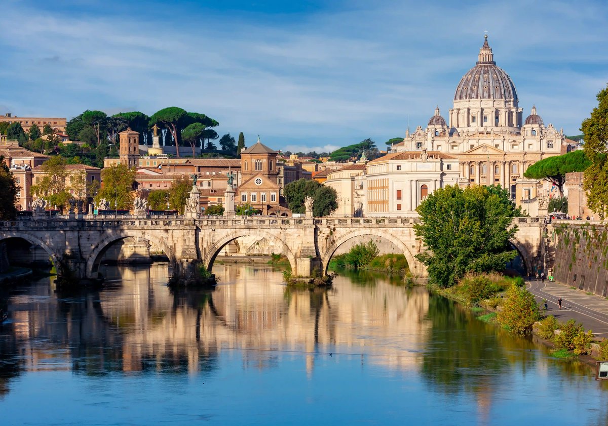 Blick auf den Petersdom im Vatikan mit Engelsbrücke und Tiber im Vordergrund