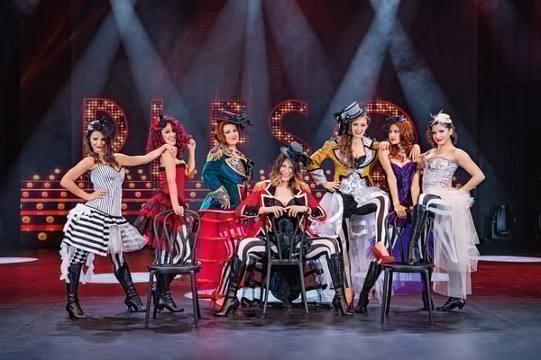 Tänzerinnen in aufwendigen Kostümen bei einer Show auf der Bühne eines Kreuzfahrtschiffes