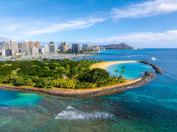 Skyline von Honolulu mit Strand, Palmen und Diamond Head im Hintergrund am Meer