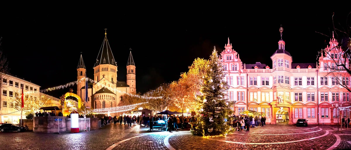 Marché de Noël à Mayence avec cathédrale illuminée et grand sapin décoré de nuit.