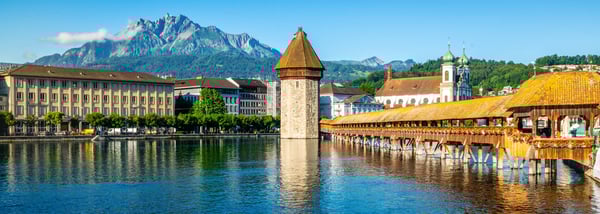 Pont de la Chapelle à Lucerne avec tour médiévale et bâtiments historiques au bord de la rivière.