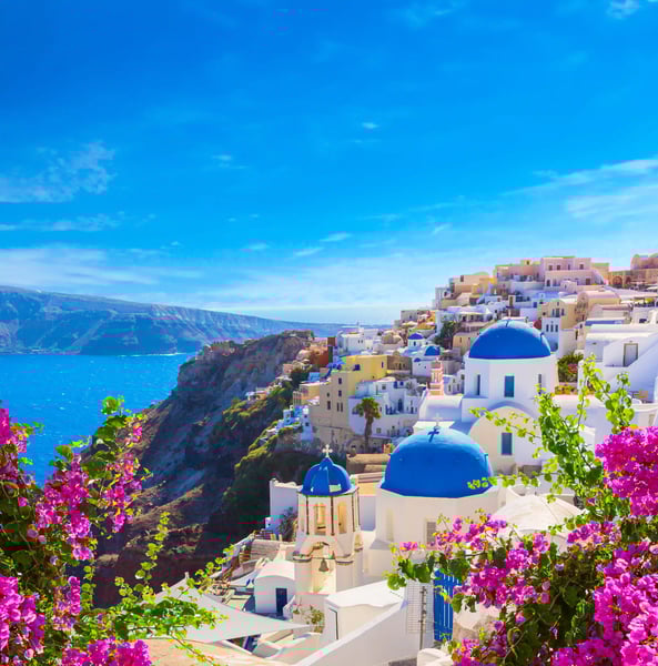 Maisons blanches et coupoles bleues de Santorin sur une falaise au-dessus de la mer.