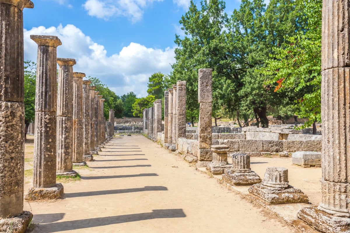 Alignements de colonnes antiques et ruines du site archéologique d’Olympie entourés d’arbres