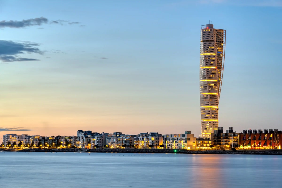 Turning Torso à Malmö au crépuscule avec promenade du front de mer et eau calme.