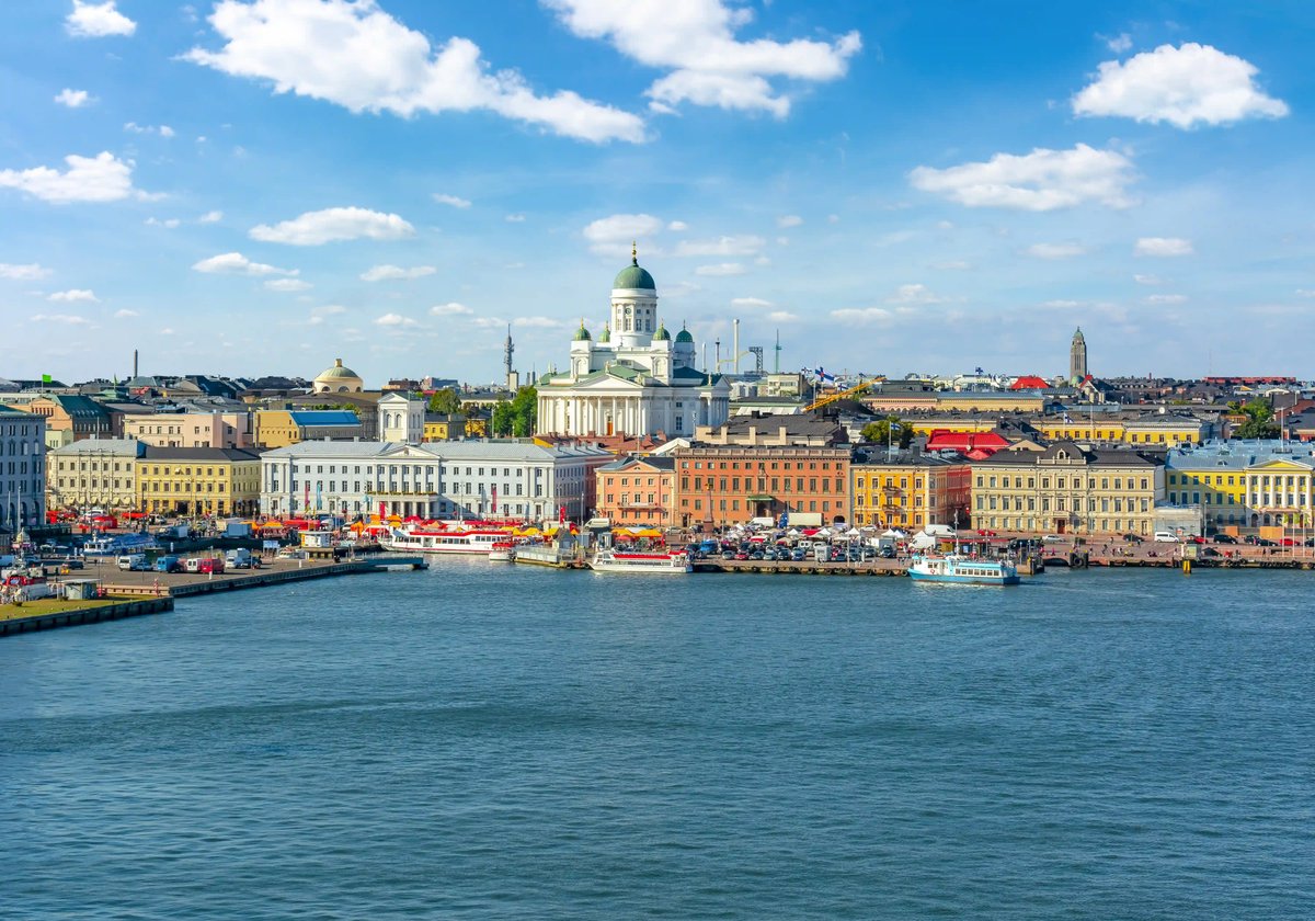 Blick über den Hafen von Helsinki mit Dom und historischen Gebäuden am Wasser.